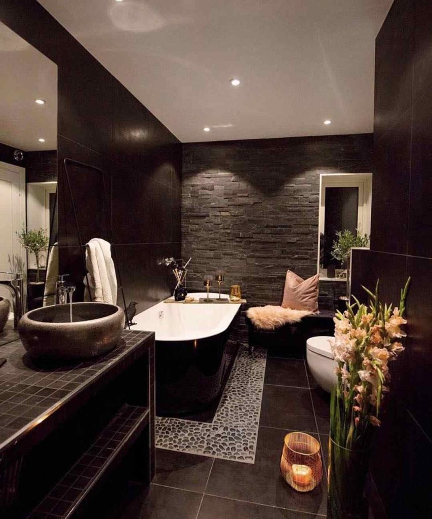 Luxurious black bathroom with stone walls and soft lighting