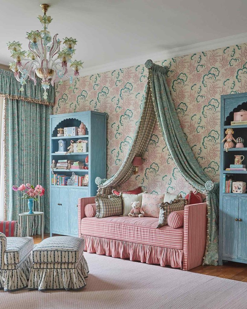 Pink striped daybed with a canopy drape, floral wallpaper, and whimsical decor elements.