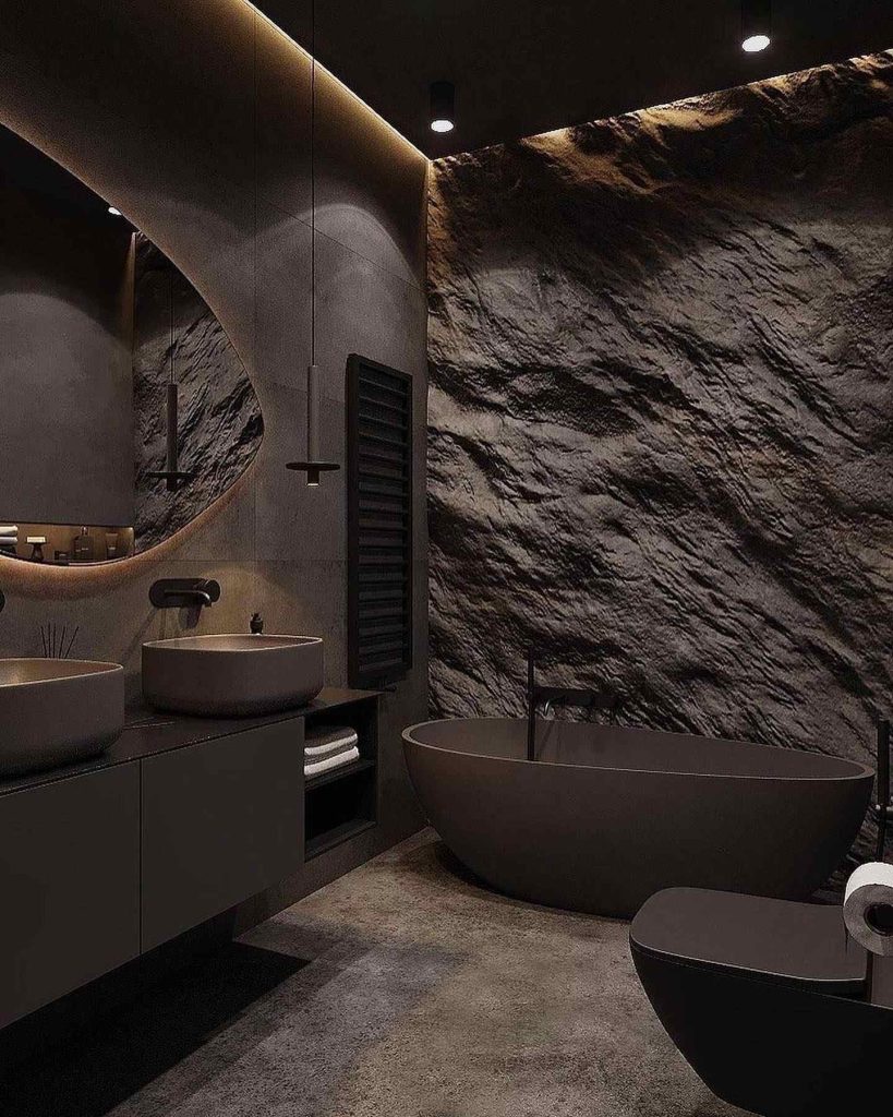 Dramatic bathroom with rugged stone wall and matte black fixtures