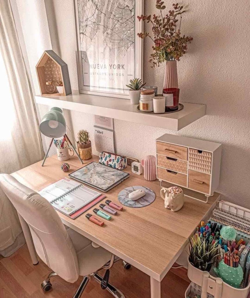 Pastel desk with pegboard, cute mug, and plants.