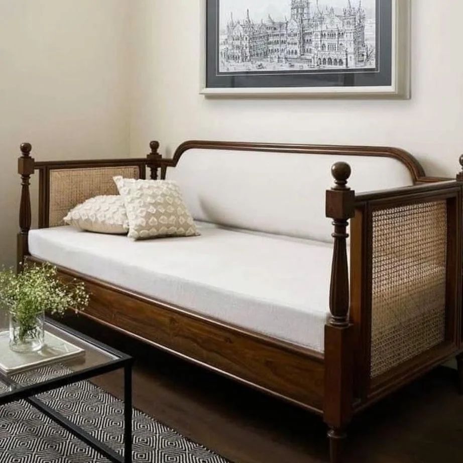 Cane and wood daybed with minimalist cushions, paired with monochrome wall art.