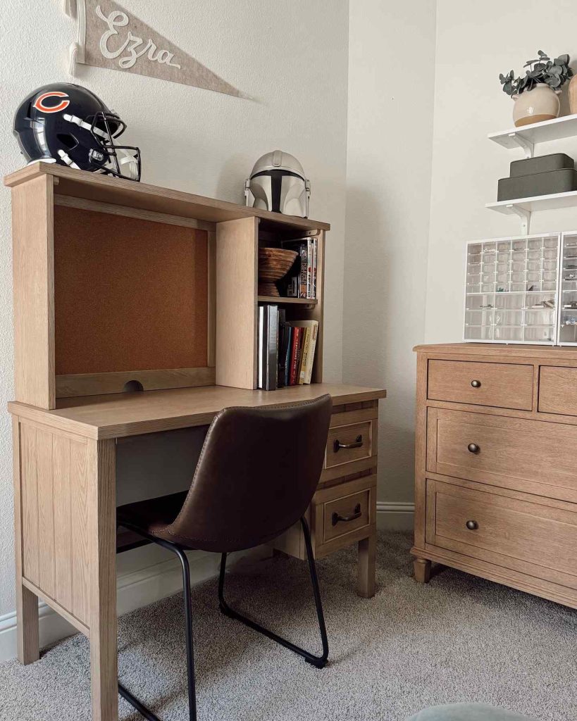 Rustic wooden desk with a leather chair and decor.