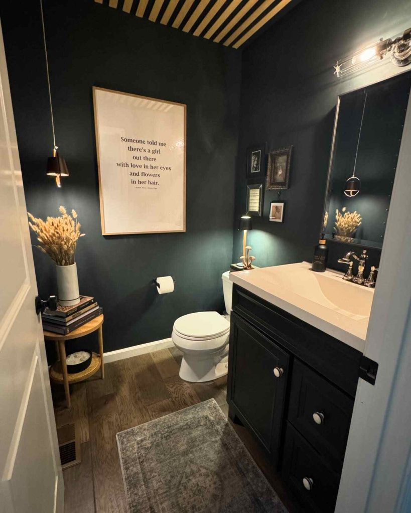 Cozy bathroom with dark green walls, layered textures, and framed quote