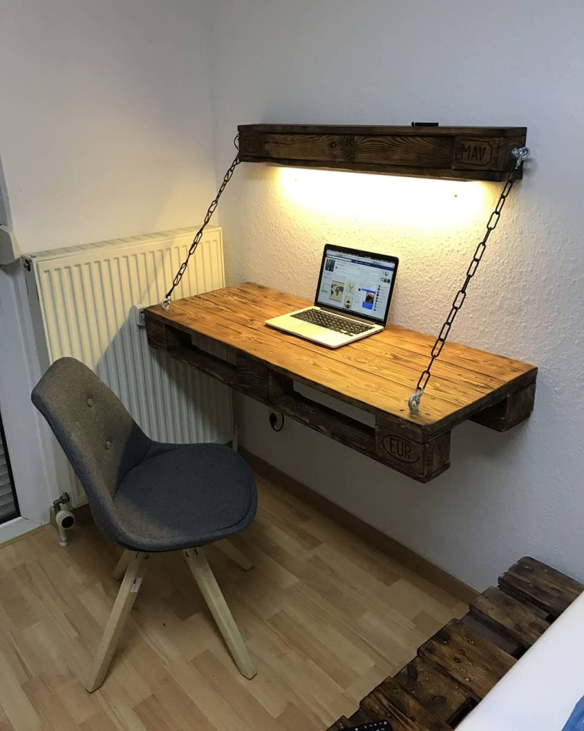 Industrial wall-mounted desk with rustic lighting.