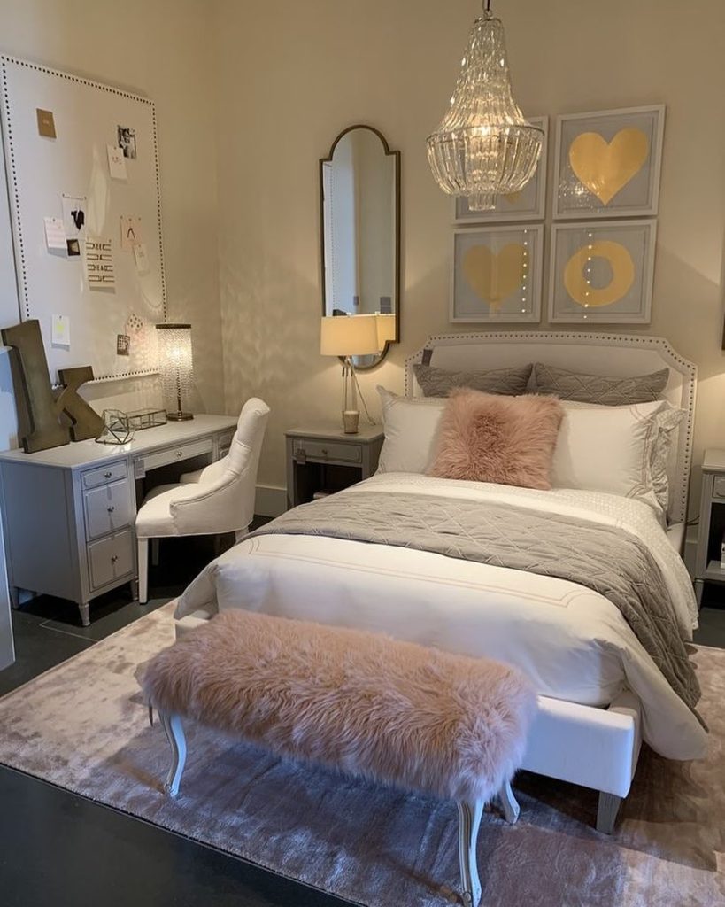 Elegant bedroom with blush pink fluffy bench and gold accents.