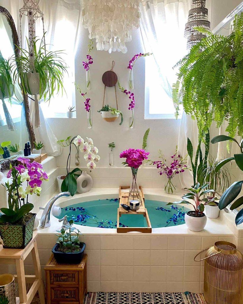 Bohemian bathroom with orchids, cascading ferns, and turquoise bathwater.
