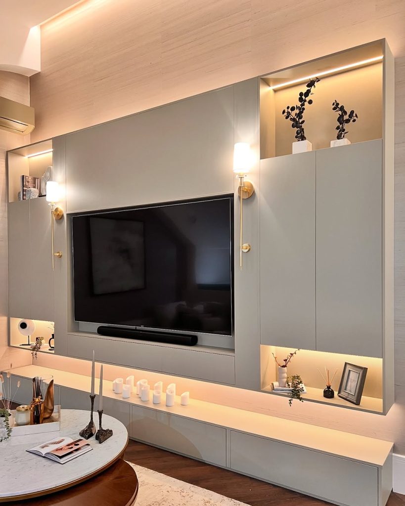 Vertical wood slat TV wall with floating console and modern lighting.
