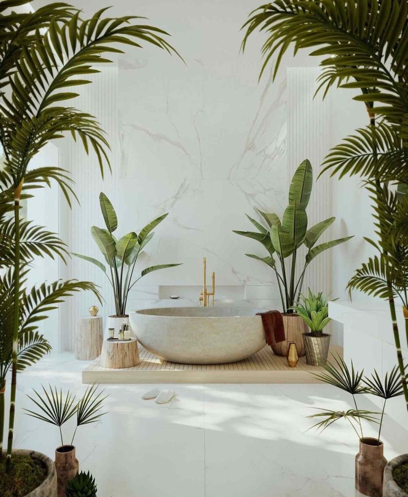 Minimalist bathroom with freestanding tub, palm plants, and golden accents.
