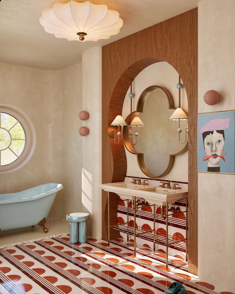 Artistic bathroom with a blue clawfoot tub and bold patterned tiles.
