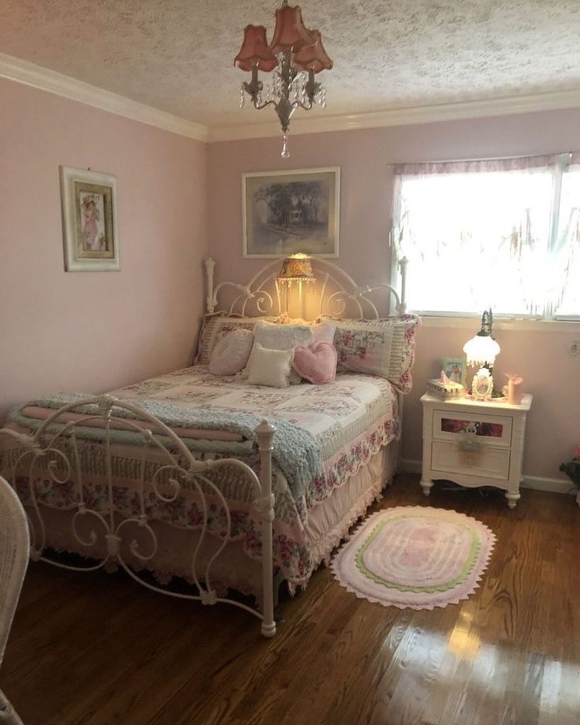 Vintage-style bedroom with floral bedding, pink walls, and soft lighting