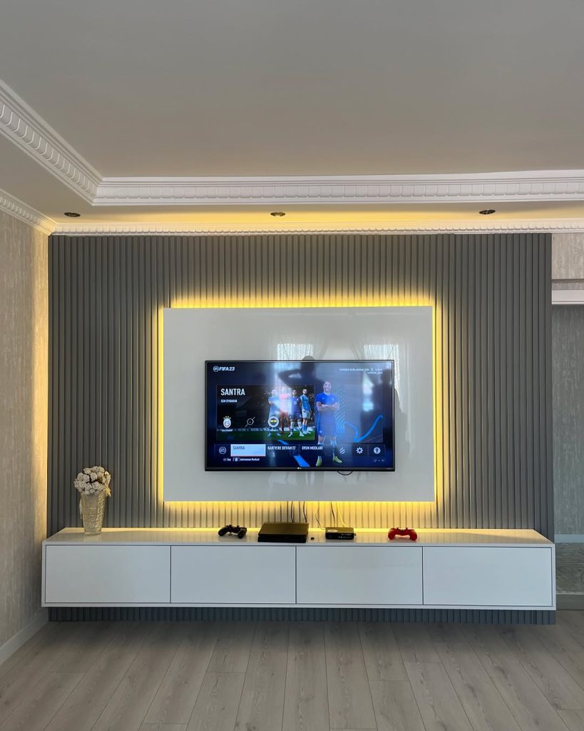 Modern TV setup with textured panels and warm yellow lighting.
