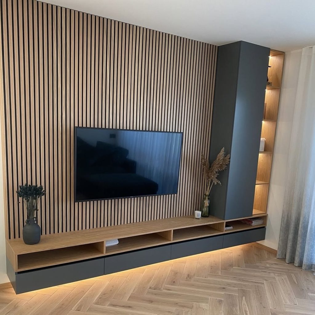 Contemporary TV wall with vertical slats, floating console, and cozy lighting.
