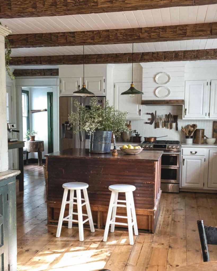 Modern rustic kitchen with green industrial pendant lights and weathered wood island.
