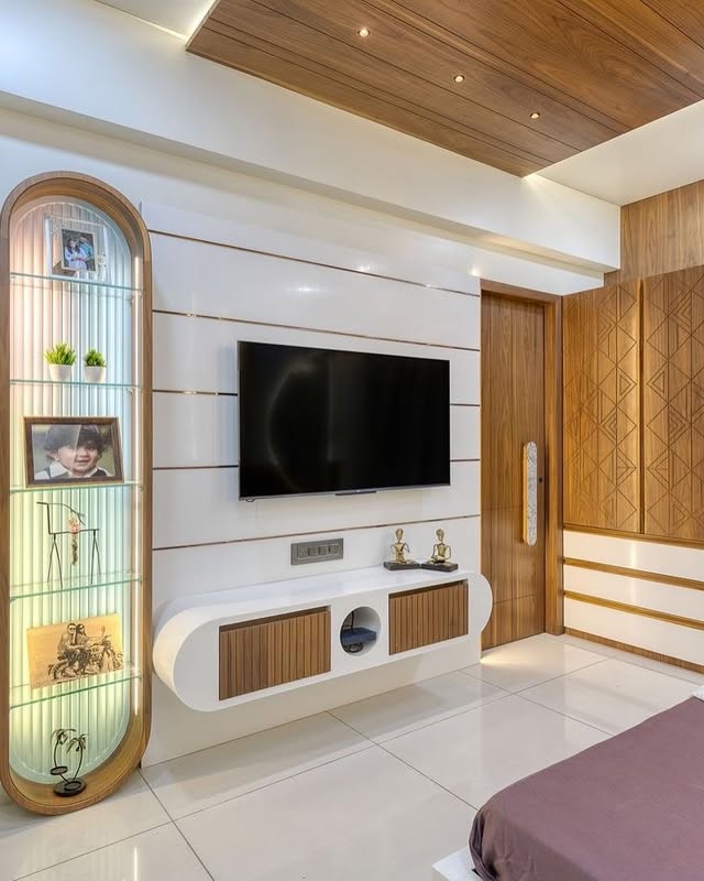 Glossy white and wood TV unit with curved shelving and decor accents.
