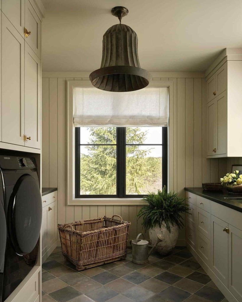 Rustic laundry room with stone counters, wooden beams, and a large wicker basket.
