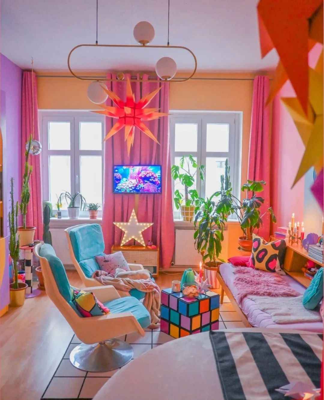 Playful living room with Rubik's cube table, teal chairs, and retro star decor.
