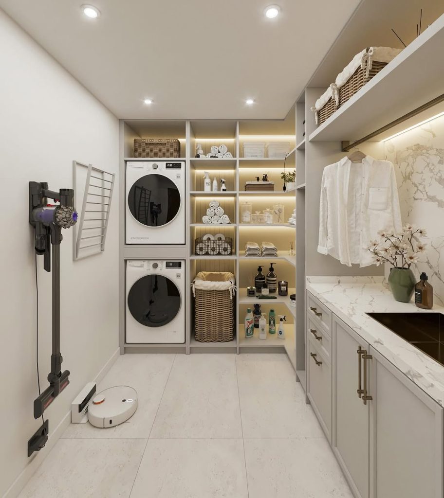 Luxury laundry room with stacked machines, open shelves, and a marble countertop.
