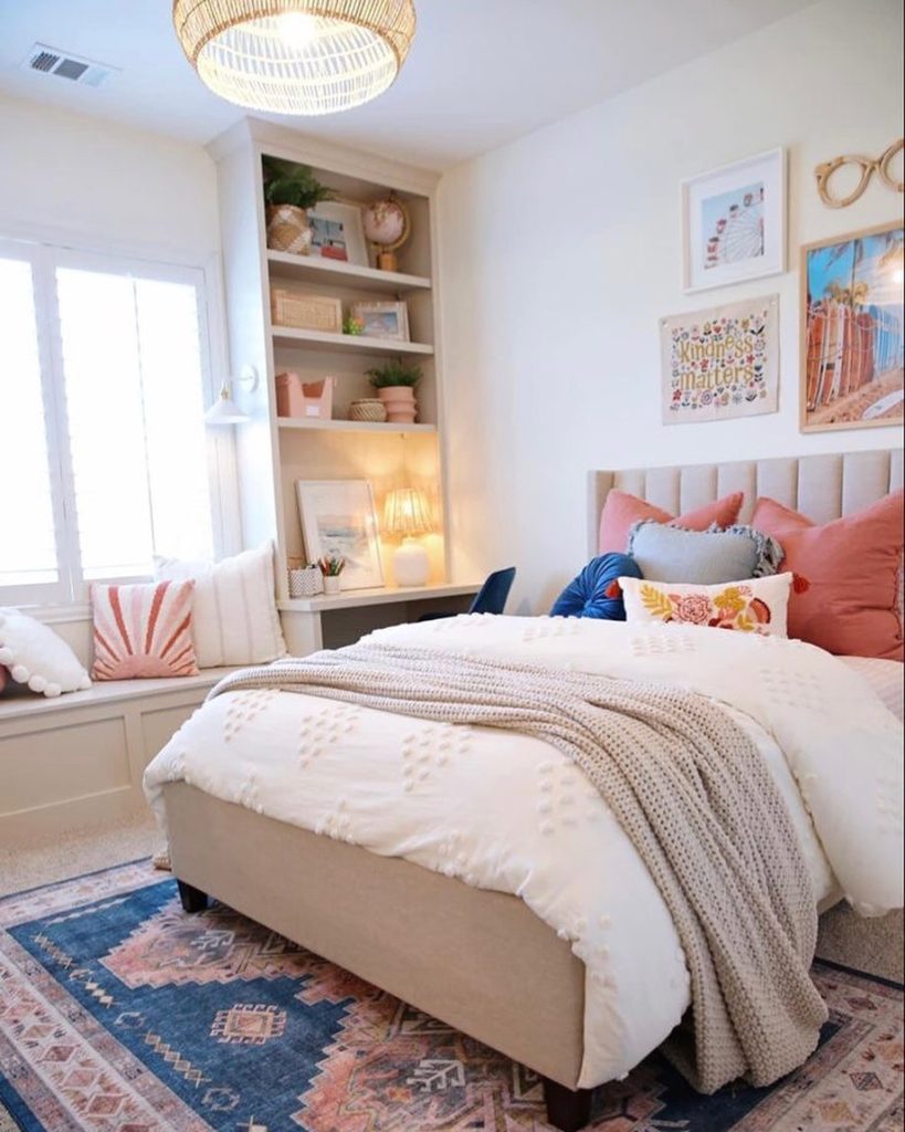 Bright bedroom with built-in shelves, pastel accents, and cozy textiles