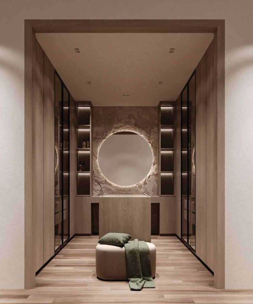 Minimalist dressing room with circular backlit mirror and earthy tones.
