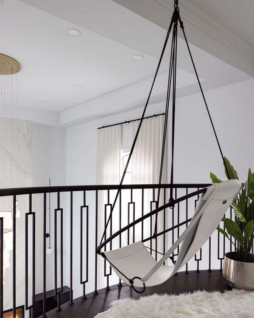 Modern black-and-white swing in a sleek, minimalist corner.
