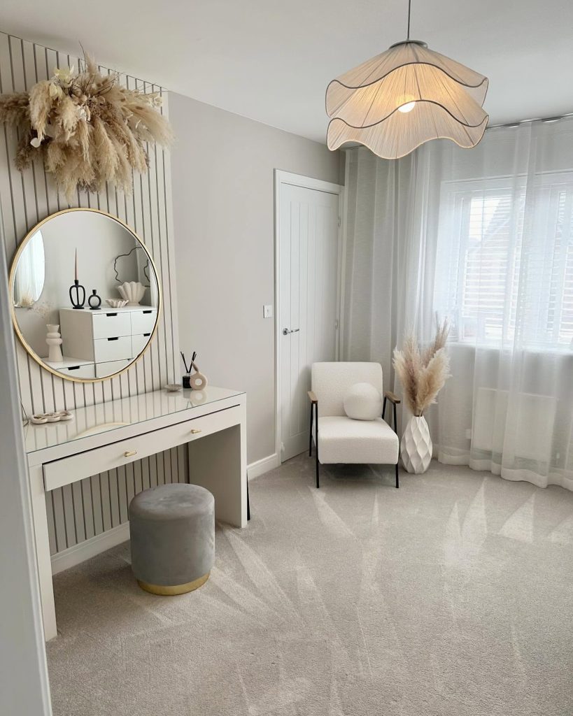 Neutral dressing room with pampas grass and gold-accented vanity.
