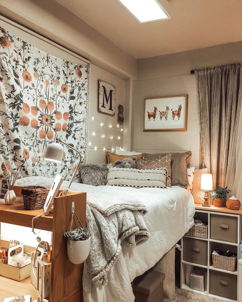 Rustic dorm featuring a floral tapestry, earthy tones, and warm fairy lights for a cozy feel.
