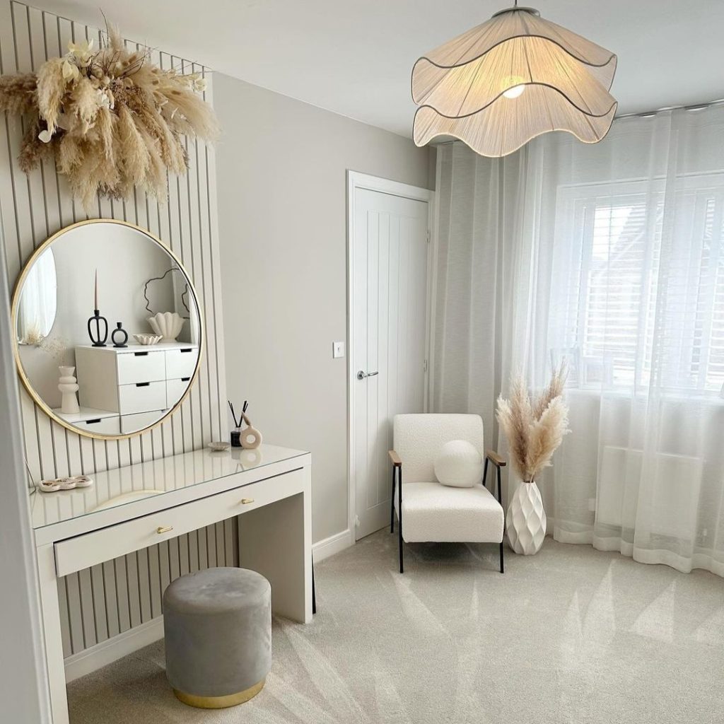 Elegant dressing space with slatted wall and gold-framed mirror.
