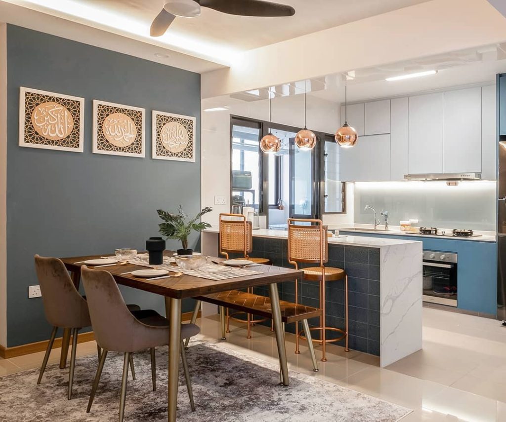 Modern kitchen with blue accents and copper lighting.
