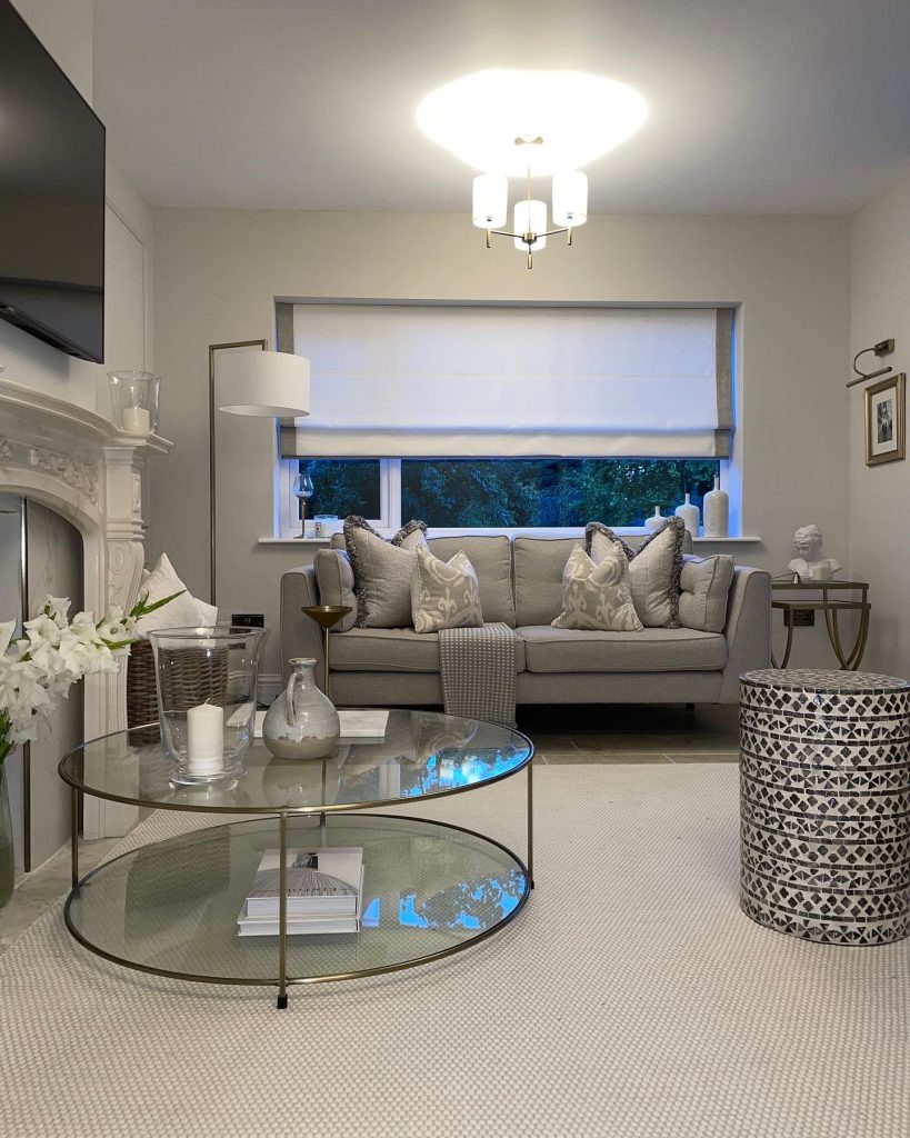 Sophisticated grey living room with a glass coffee table and elegant accents.
