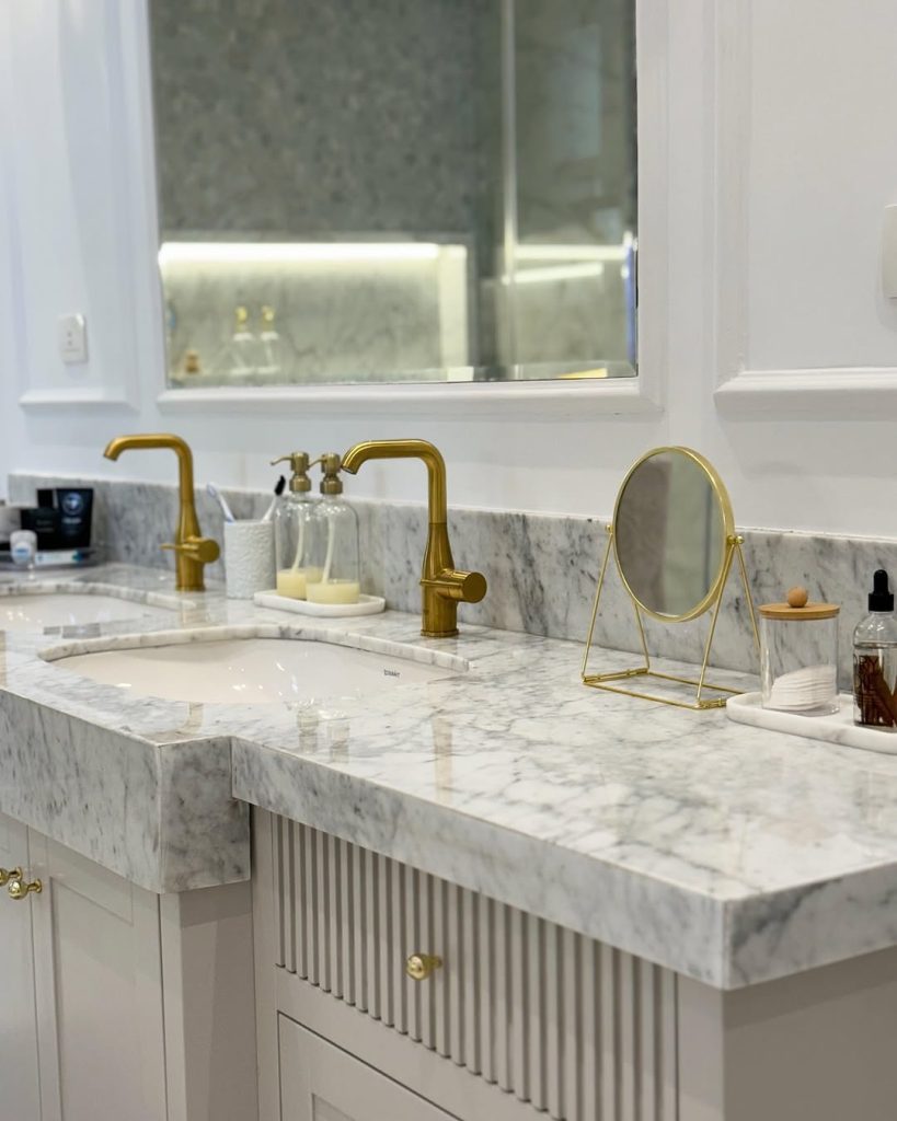 Classic marble double vanity with gold faucets and soft white tones