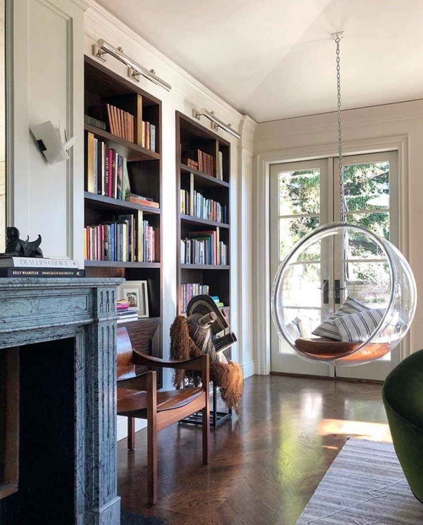 Transparent bubble swing in a sophisticated home library.
