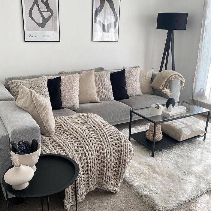 Textured grey living room with knit throws and modern decor.
