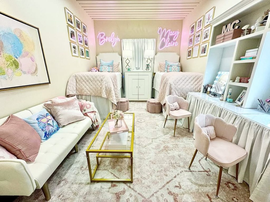 Elegant dorm with blush tones, a personalized gallery wall, and custom neon name signs.
