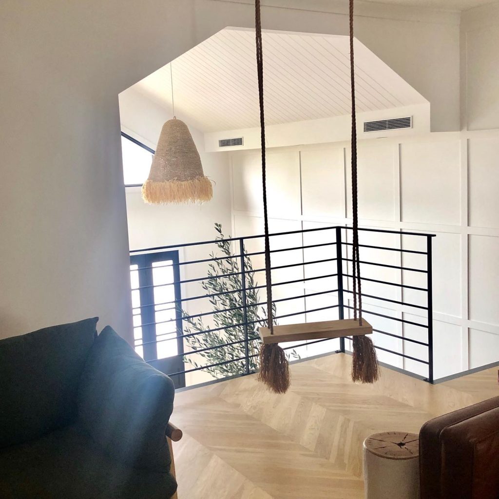 Simple wooden swing in a cozy loft with natural light.
