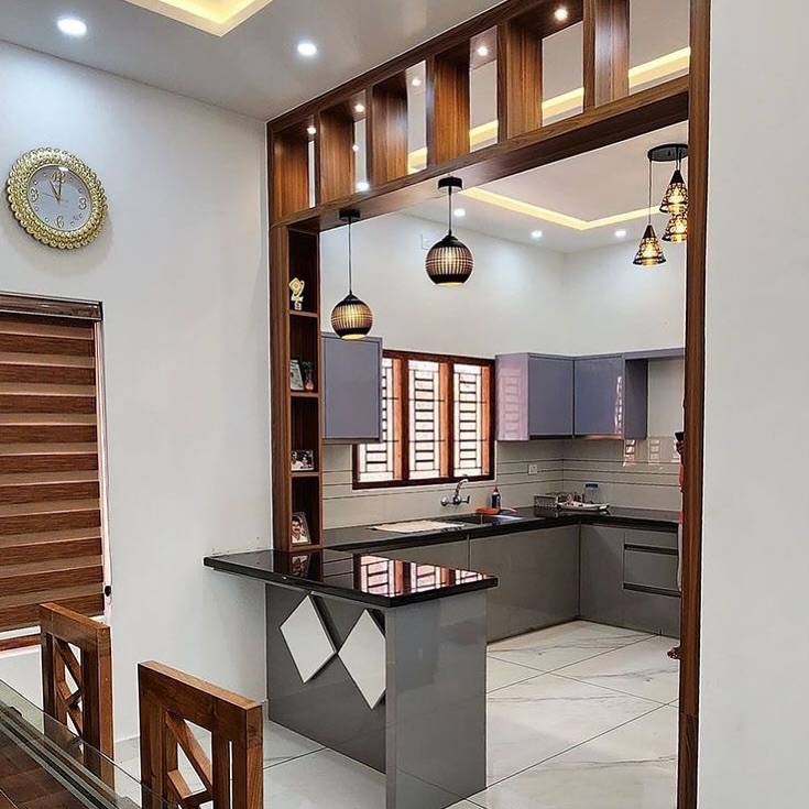 Open kitchen with sleek black countertops and wood accents.
