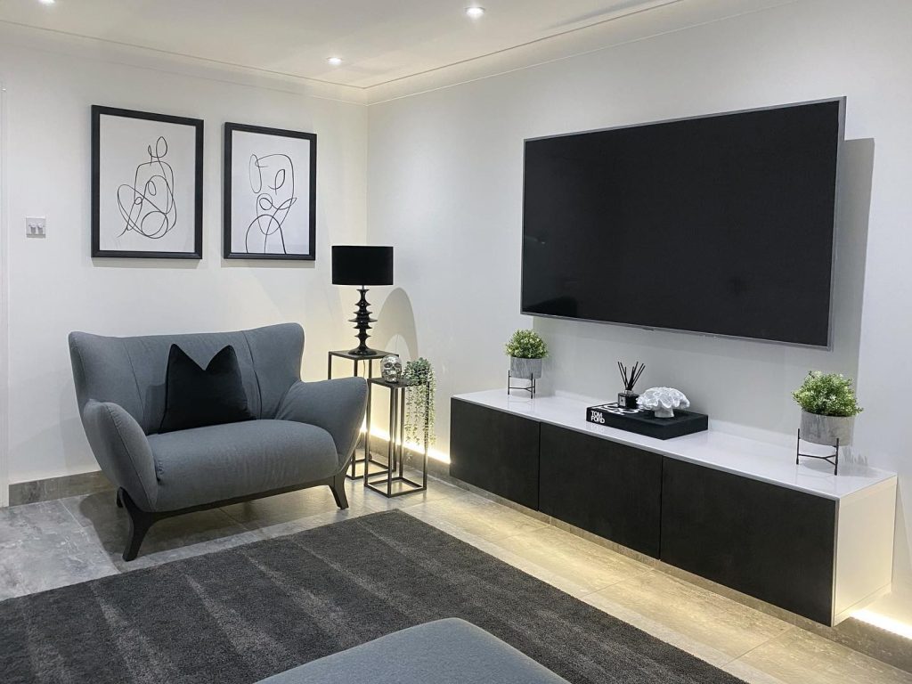 Minimalist grey living room with abstract art and clean lines.
