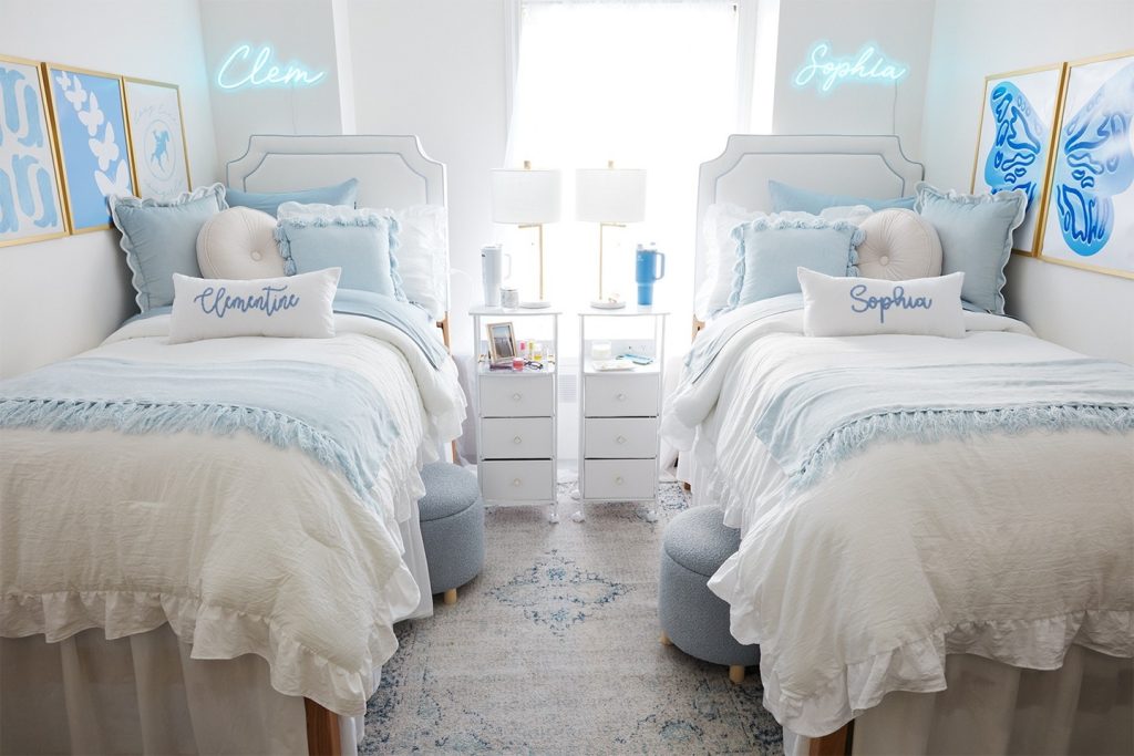 Serene dorm with soft blue and white tones, fringe details, and personalized decor.
