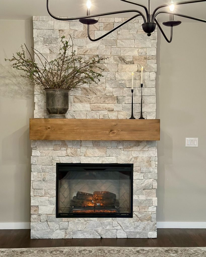 White brick fireplace with minimal decor in a bright, airy living room.
