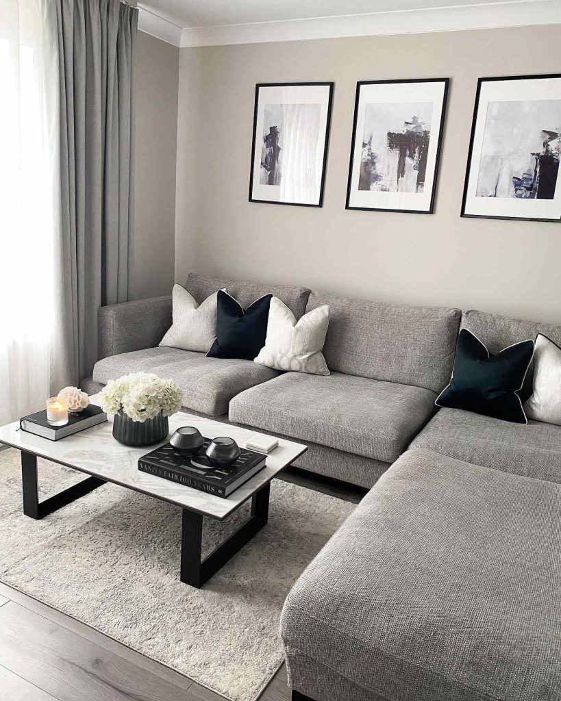 Contemporary grey sectional with marble coffee table and abstract artwork.
