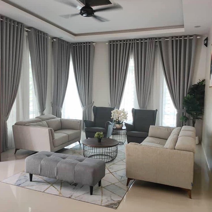 Bright and spacious grey living room with tall curtains and neutral seating.
