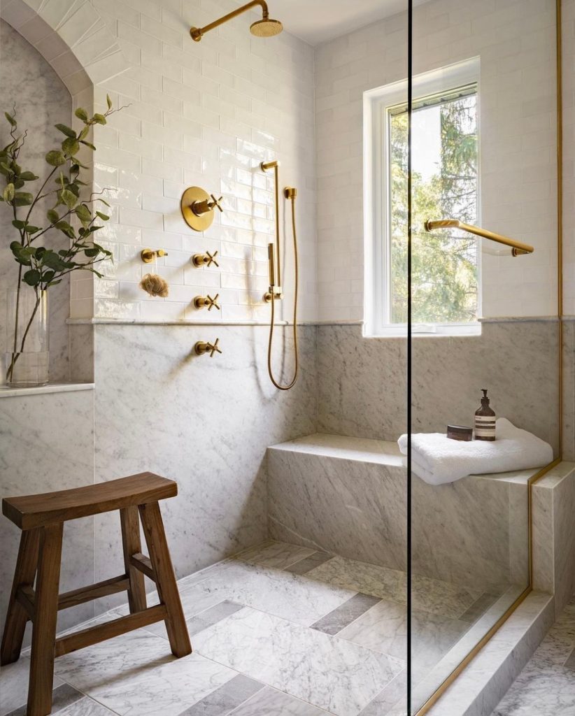 Textured marble bench and walls in a minimalist shower design.