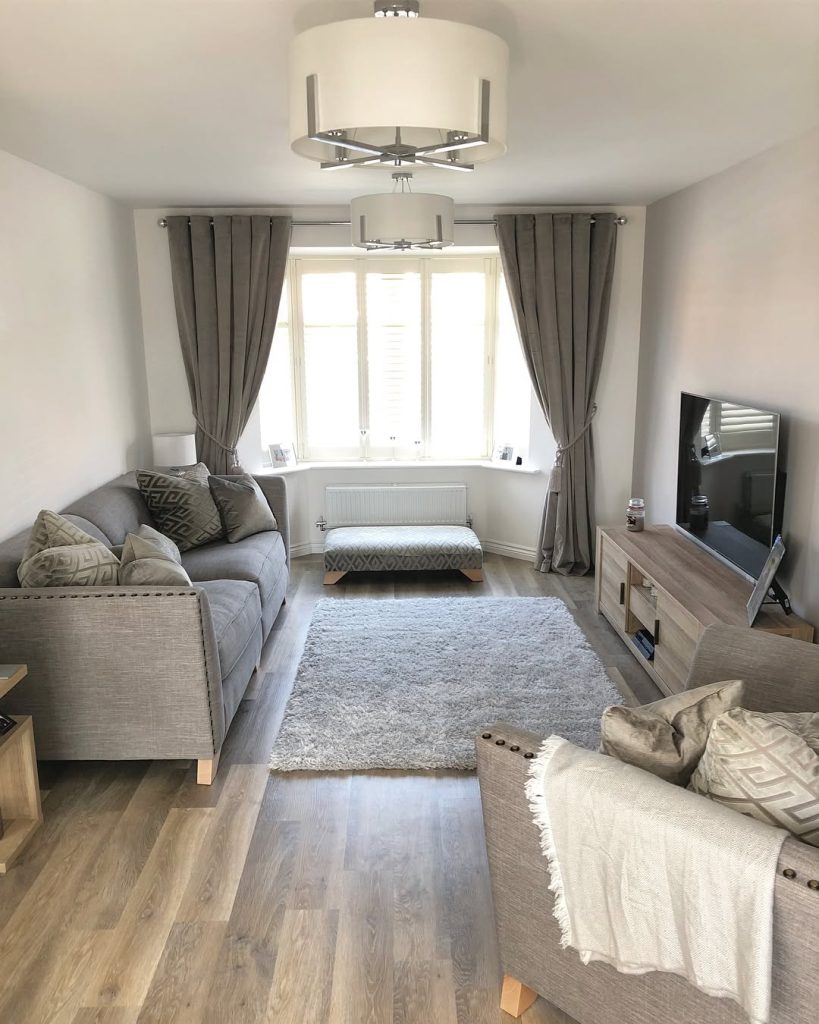 Compact grey living room with natural light and wooden flooring.
