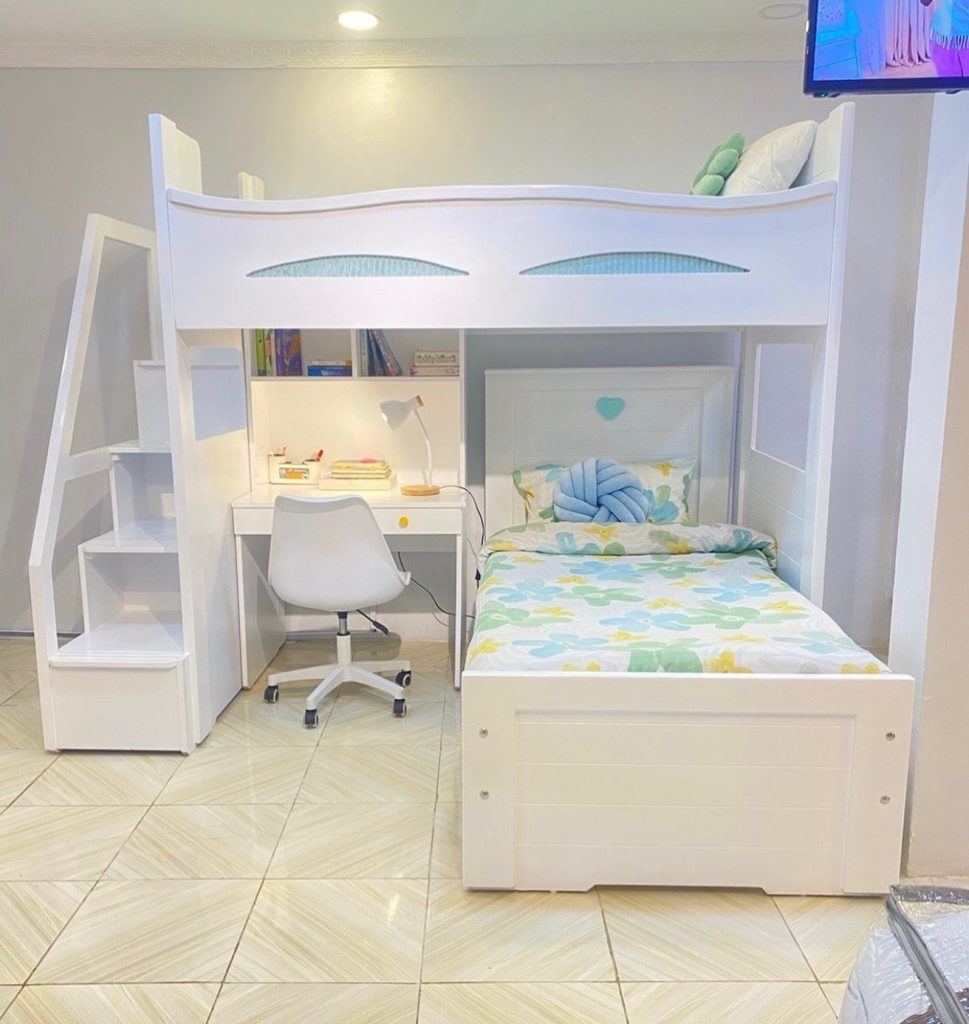 Minimalist loft bed with built-in desk, white furniture, and pastel bedding in a compact dorm room.
