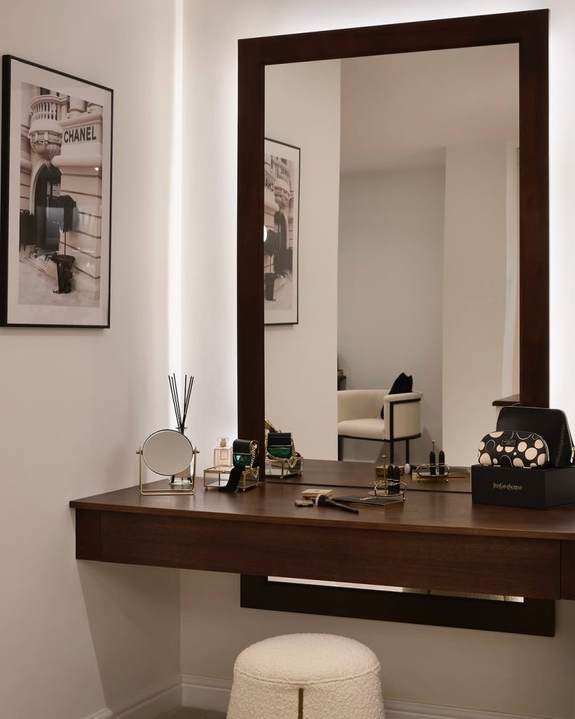 Vanity setup with dark wood accents and a chic Chanel wall art.
