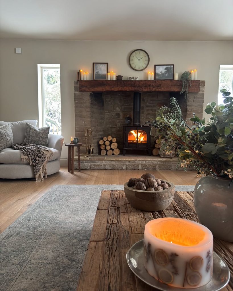 Minimalist fireplace with candles and a rustic brick mantel in a serene setting.
