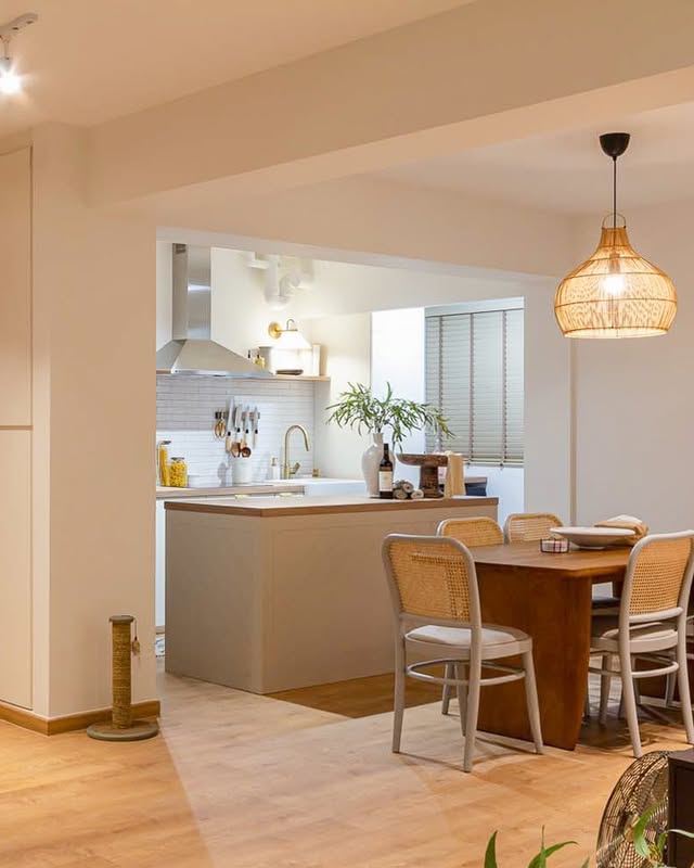 Cozy boho kitchen with cane-back chairs and rattan light.
