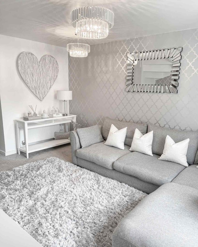 Elegant grey sofa with textured decor and statement light fixtures.
