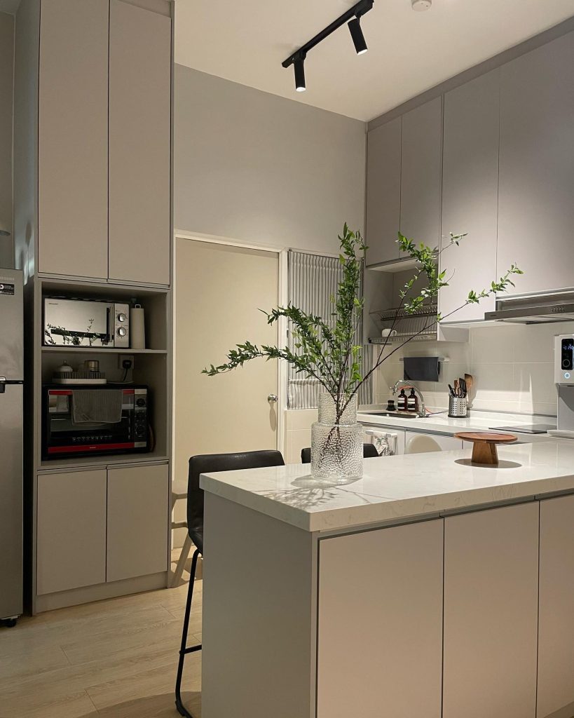 Minimalist kitchen with greenery and marble island.
