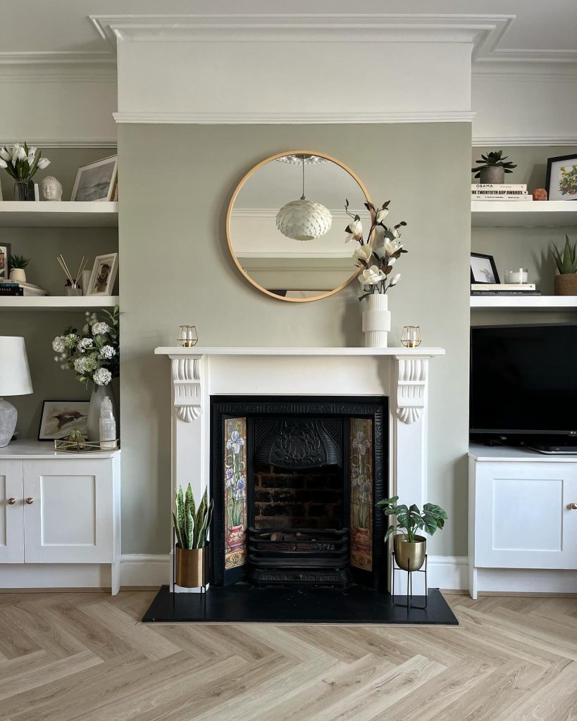 Sophisticated fireplace with greenery, candles, and holiday-inspired accents.
