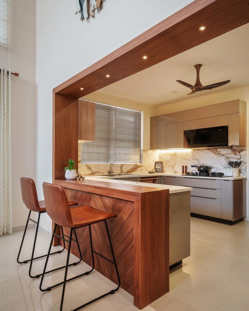 Warm wood kitchen with chevron breakfast bar and marble backsplash.





